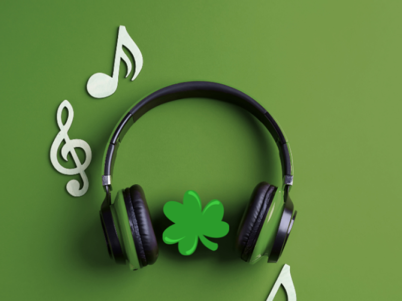 Stock image of headphones, music notes and shamrock on green background