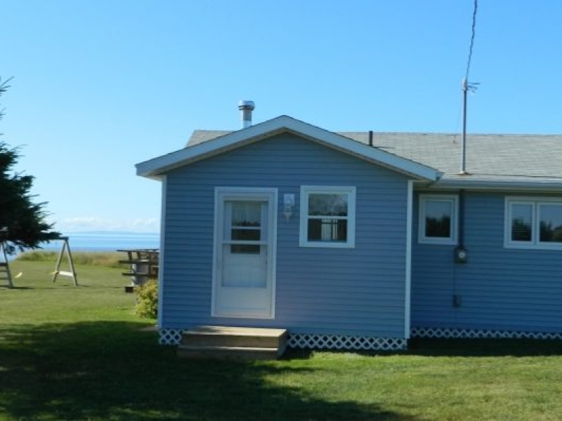 Photo of rear view of blue cottage with porch