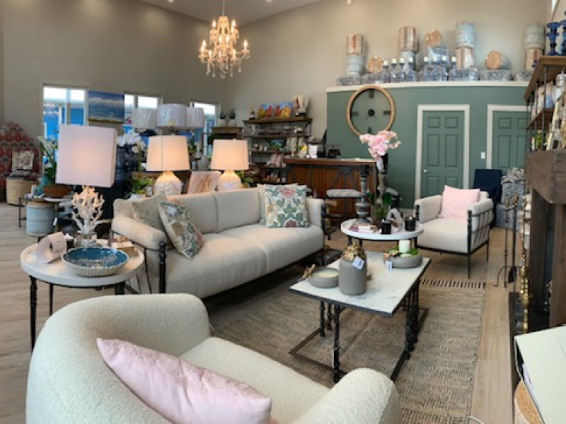 inside photo of a living room set up with accent tables and green couches