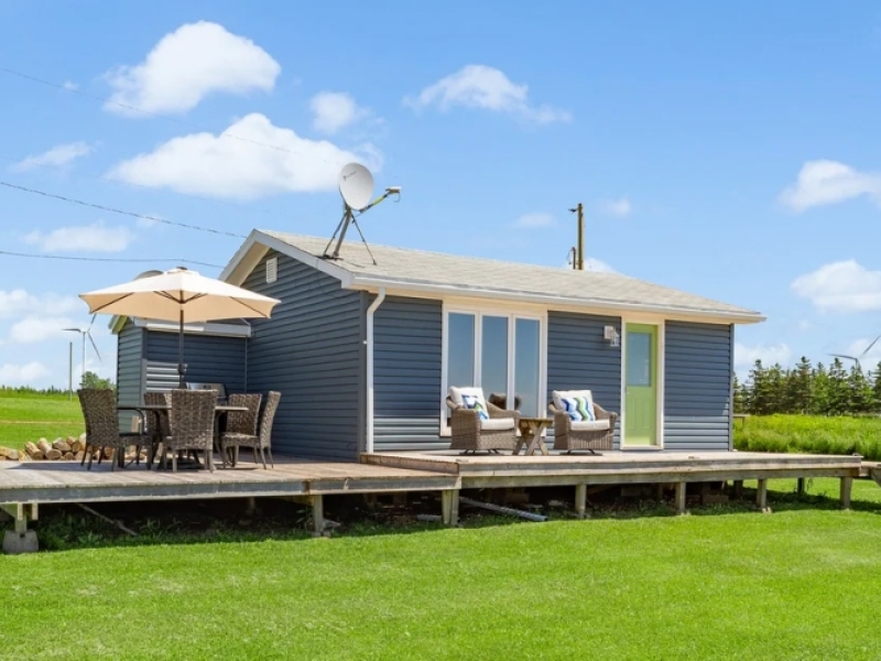 Small blue cottage with deck and patio table