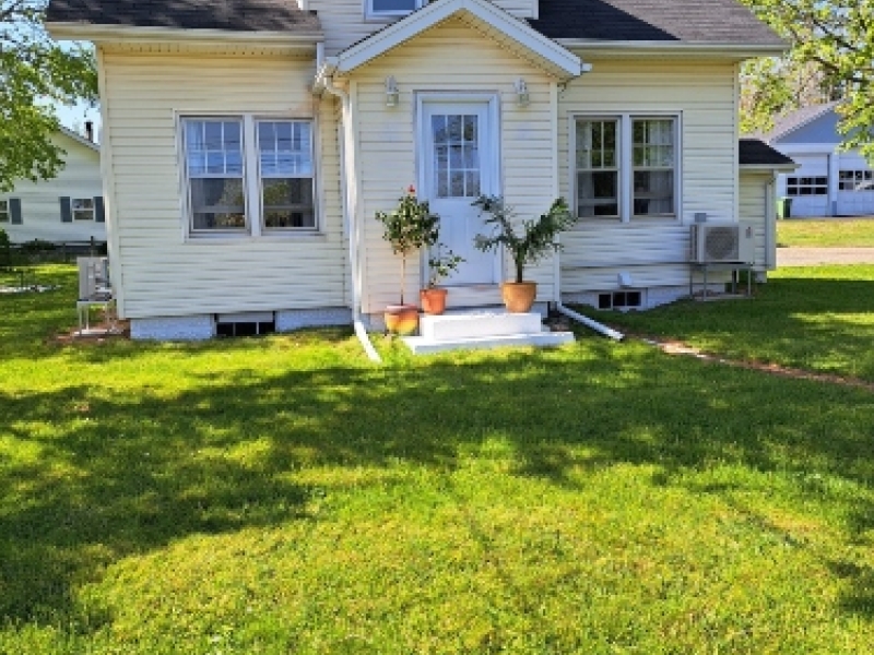 outside view looking at the front view of a two story yellow house