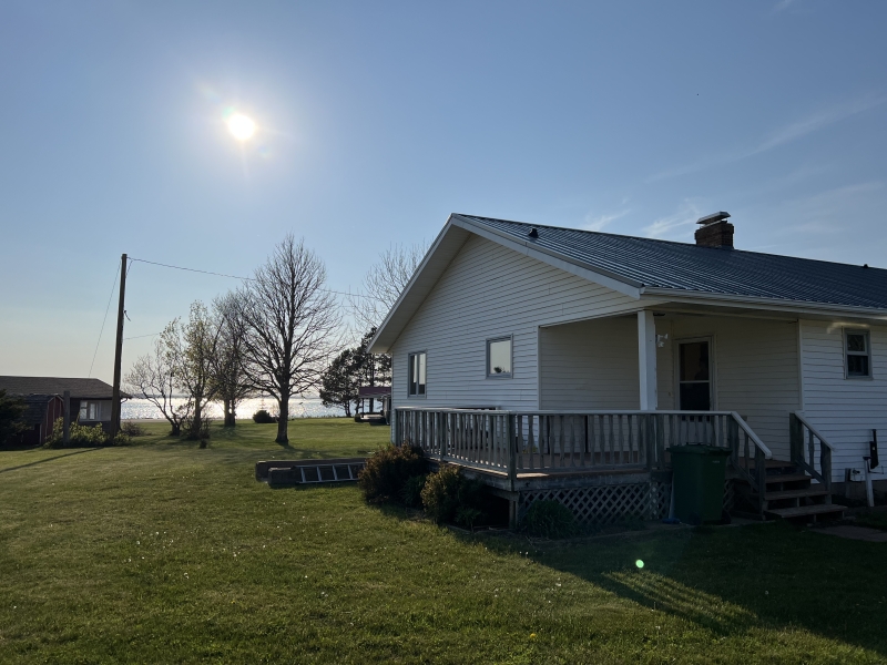 outside photo of white cottage with deck