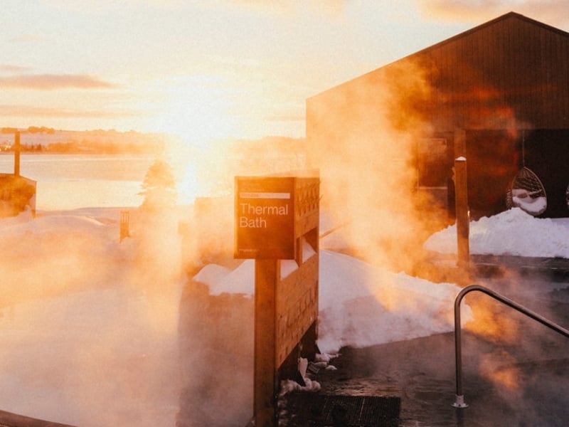 Thermal bath and steam rising outdoors at Mysa Spa with St. Peter's Bay in background