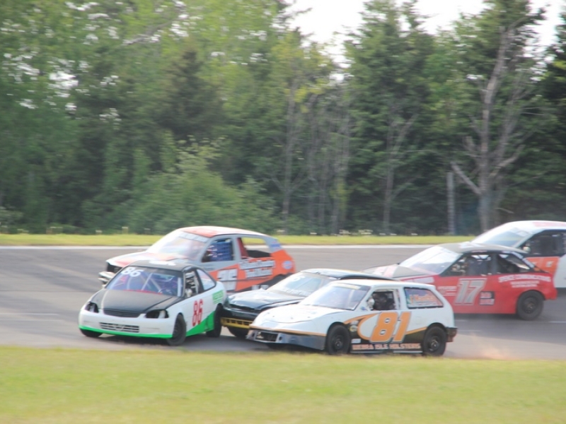 Six cars racing at the Oyster Bed Speedway