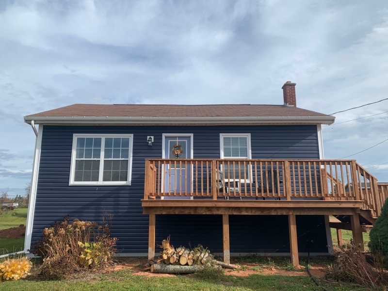 outside view of the front of blue cottage with deck