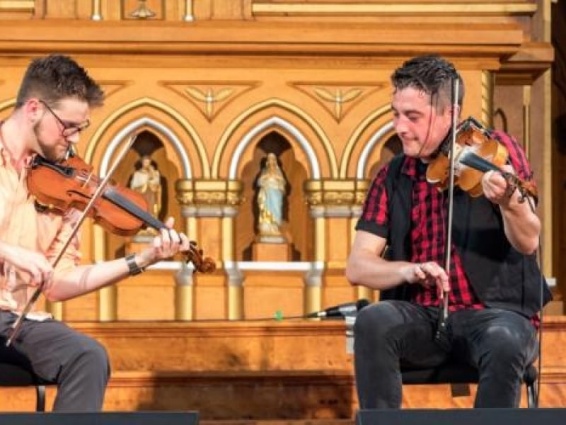 Two musicians play fiddles during PEI Small Halls event at St. Mary's Church