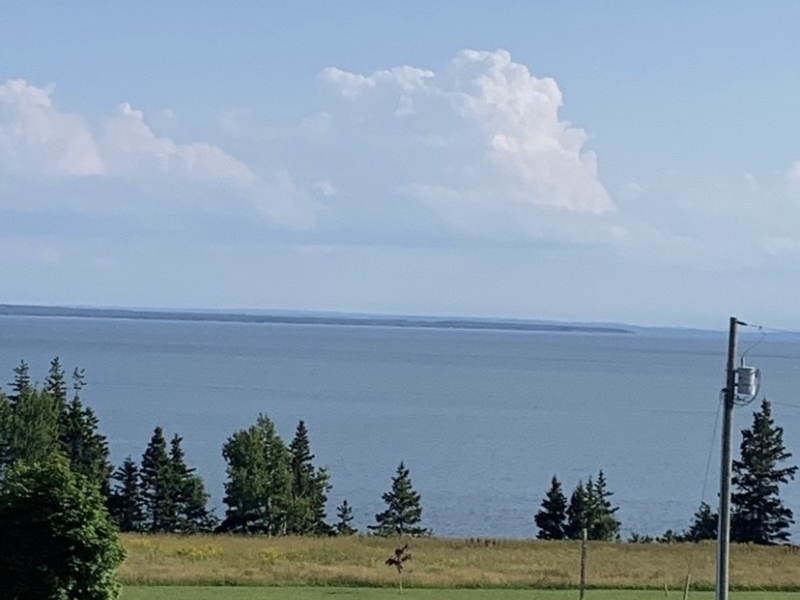 outside view overlooking the Northumberland strait, field trees and water.