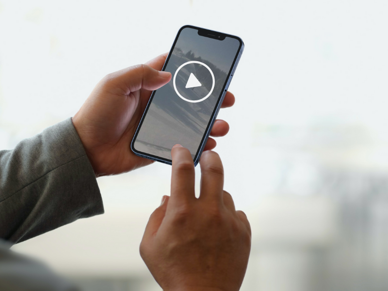 Stock image of person holding mobile phone with webcam displayed