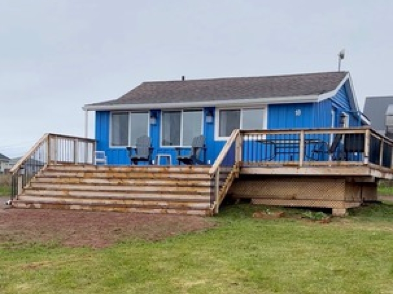 outside photo of blue cottage with deck on front