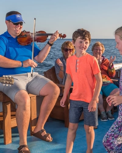 Fiddling Fisherman, children dancing, boat, ocean