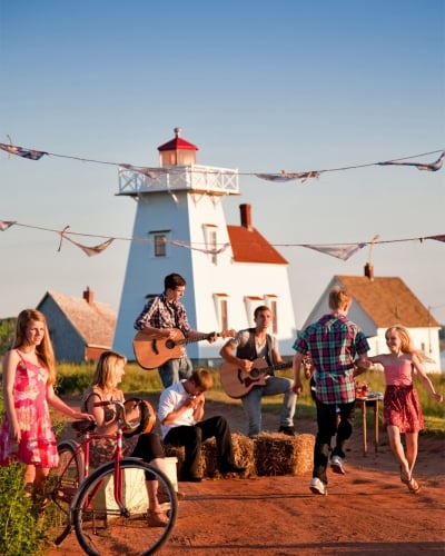 Dancers and musicians perform on red dirt road in North Rustico Harbour