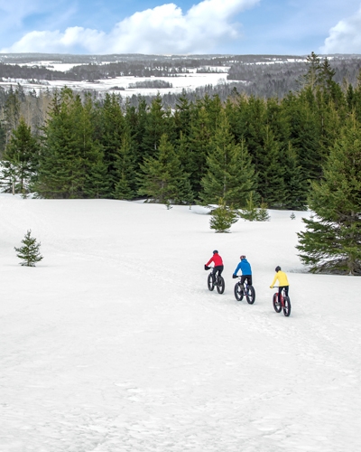 Drone view of trio fatbiking at Bonshaw Provincial Park in winter