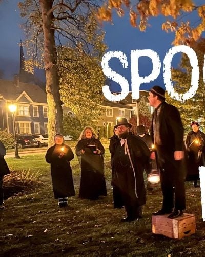 Group dressed in black at night in Rochford Square with text "Spooky Walk"