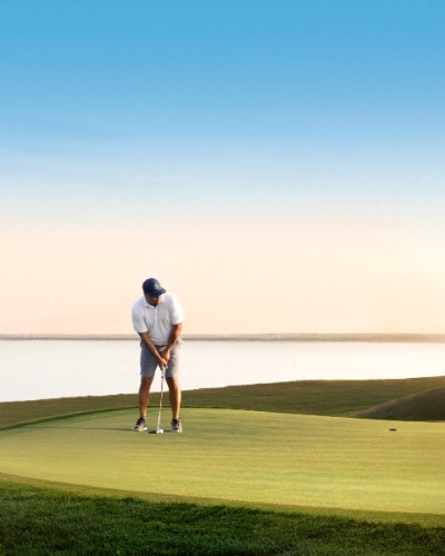Golf, Prince Edward Island, Canada Golf on putting green with ocean view in background