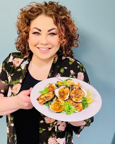 Ilona Daniel holding a plat of baked oysters