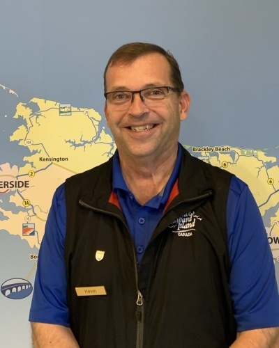 Image of Kevin Barbour standing in front of wall mural of PEI map at VIC