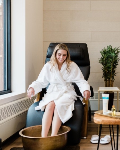 A couple of women enjoying a pedicure, dressed in white robes