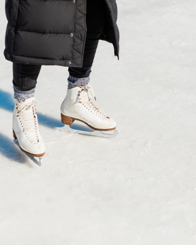 CLose-up of person wearing figure skates on outdoor rink