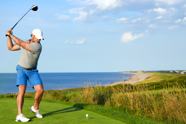 Golf swings at tee box on hole overlooking the beach at Crowbush Golf Course, PEI