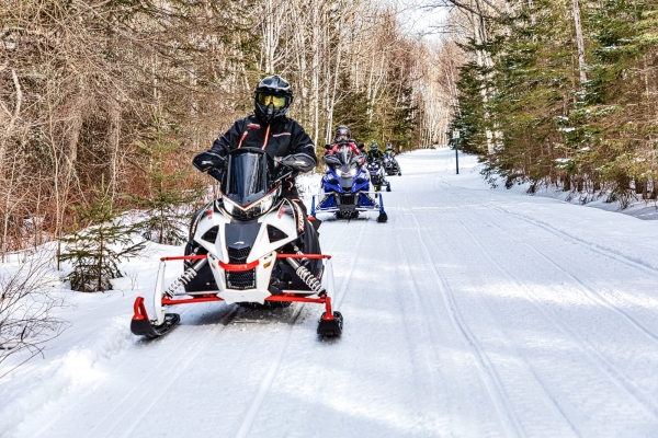 Convoy of snowmobiles on snow-covered Confederation Trail