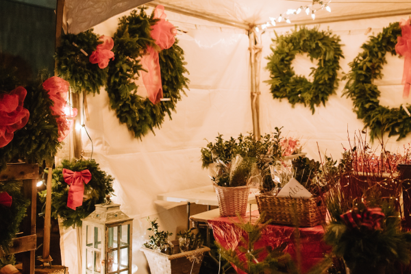 View of outdoor market booth selling evergreen wreaths