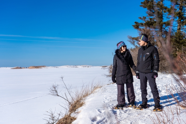 Couple snowshoe at PEI National Park in Cavendish in winter