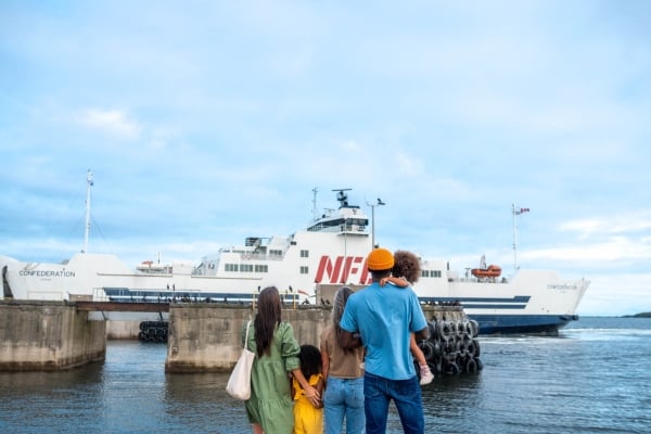 Two adults and three children watch a NFL ferry depart from PEI