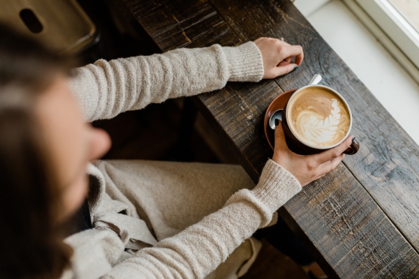 Aerial view of person at window with hot latte in hand