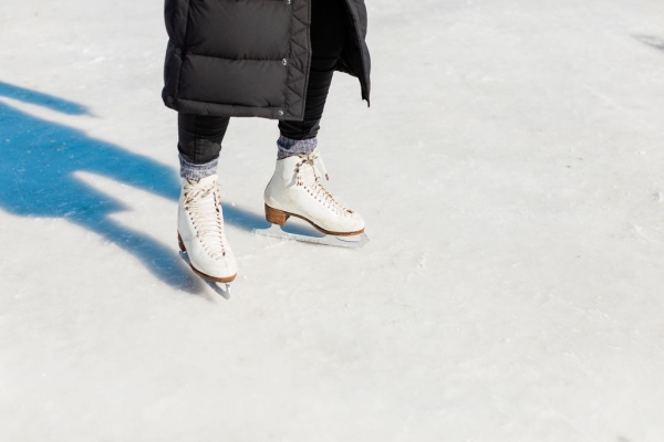 CLose-up of person wearing figure skates on outdoor rink