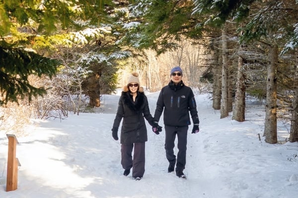 Couple walk at trail at PEI National Park in Cavendish in winter