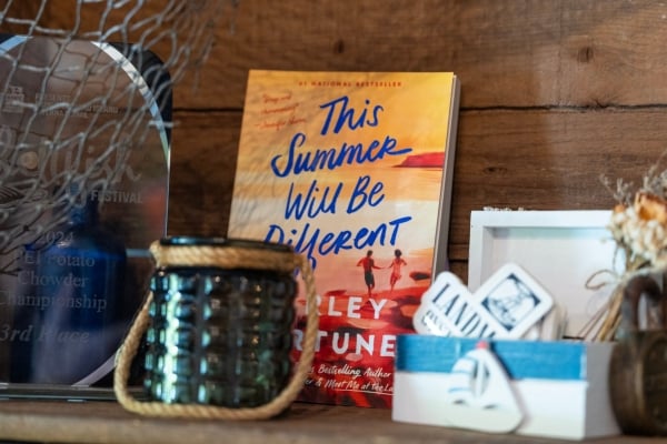 Image of the book "This Summer Will Be Different" on shelf with other PEI decor