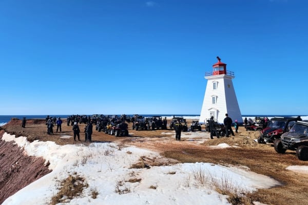 ATV club members at lookout near lighthouse in winter PEI