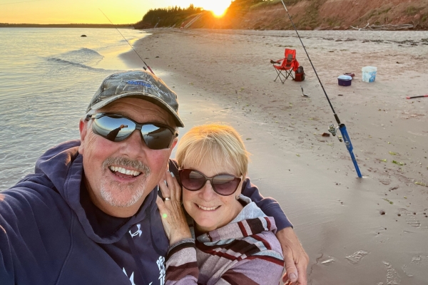 Wade and Marney Mackinnon on beach with bass fishing rods in background
