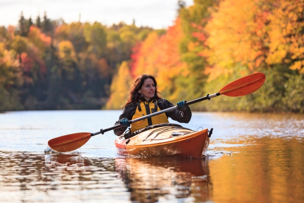 Person in kayak on river in fall