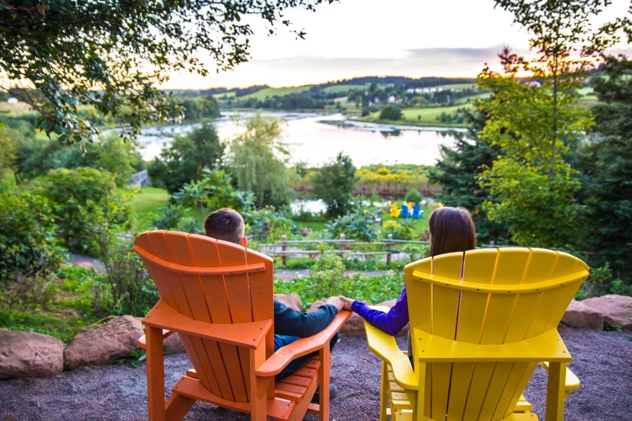 Image of couple sitting in lawn chairs overlooking the Clyde River from the Gardens of Hope in New Glasgow