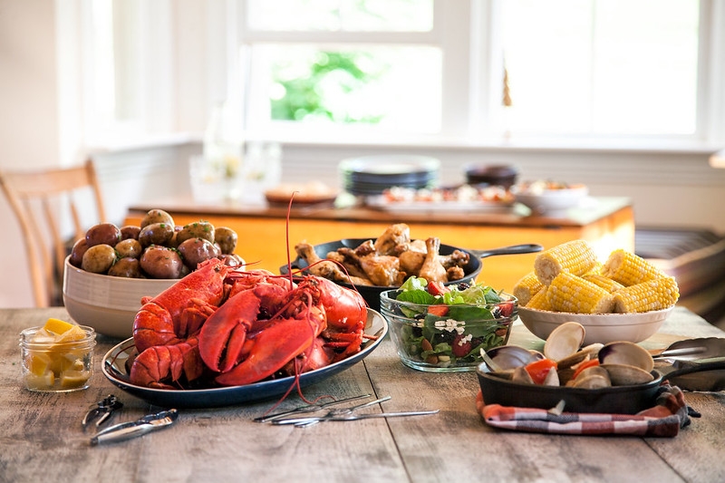 Table of fresh PEI Lobster, quahogs, salad, potatoes, corn and chicken