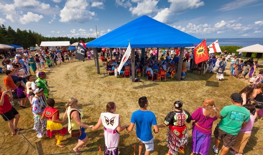 Annual Abegweit Pow Wow Image of individuals gathered in a circle in a celebration of traditional drumming and dancing at the Abegweit Pow Wow in Panmure Island on Prince Edward Island.