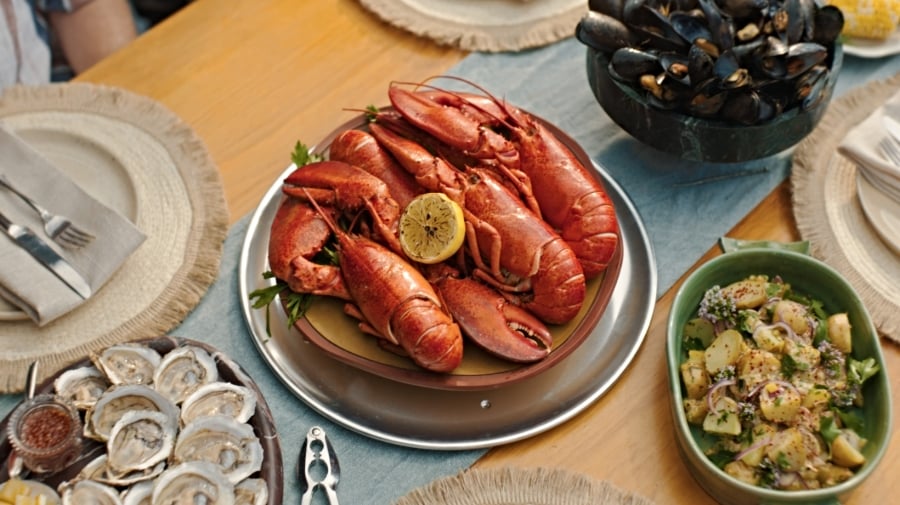 Overhead view of table set with cooked PEI lobster, mussels, oysters on the half shell and PEI potatoes
