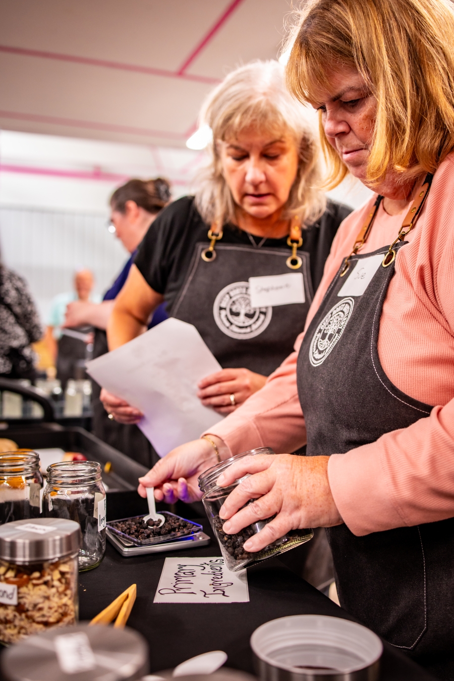 Two women preparing recipe in Distiller for a Day experience