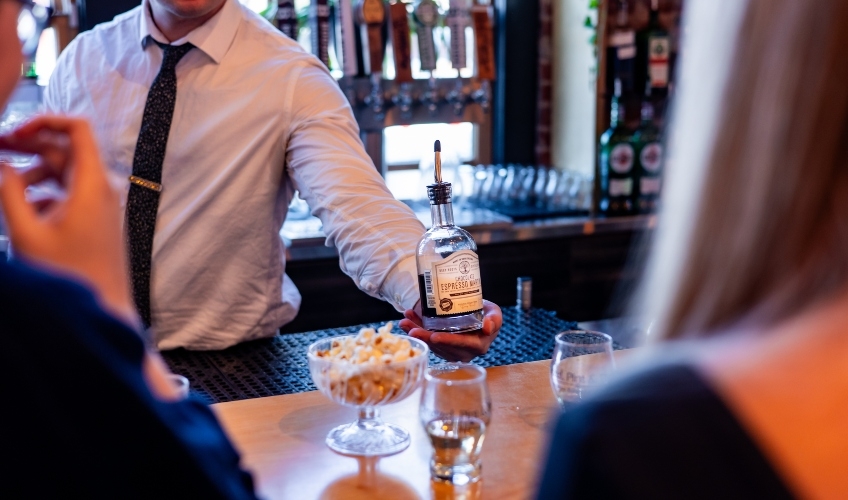 Bartender serves couple at Pint & Pickle at Founder's Food Hall & Market