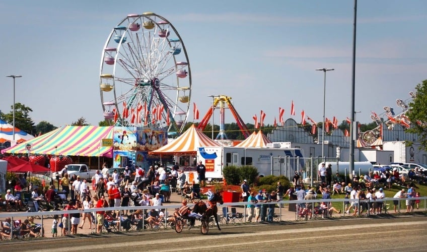 Image of Prince Edward Island's Old Home Week Festival event grounds, including harness racing, festival tents and amusement rides.