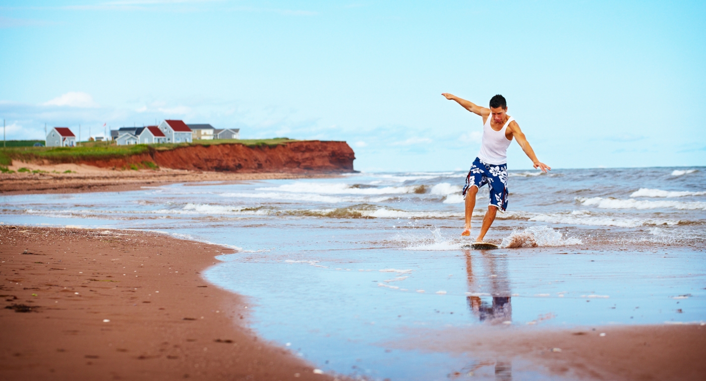 Skimboard surfing, red sand, beach Skimboard surfing, red sand, beach