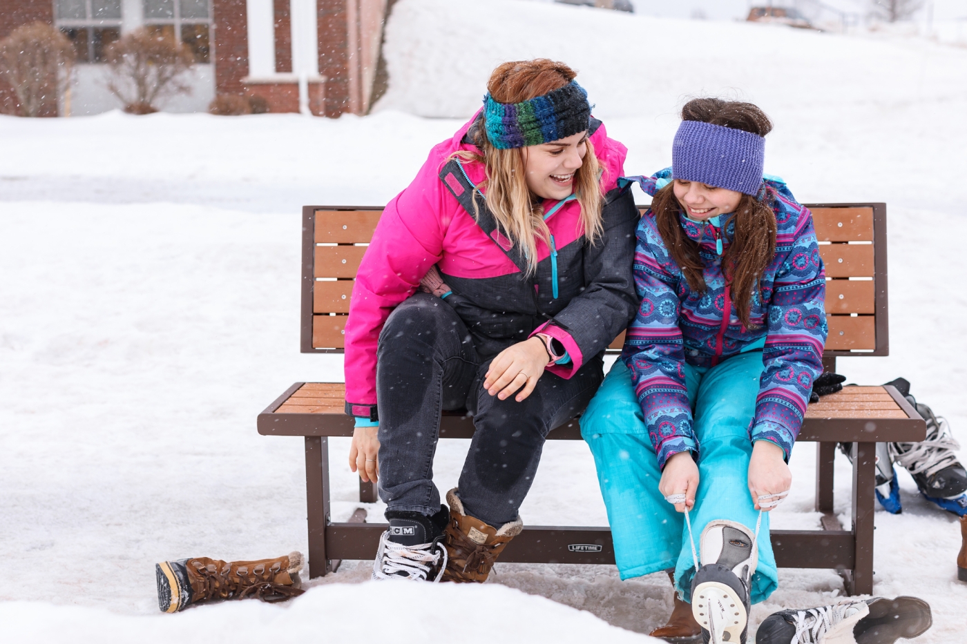 Adult and child females sitting on bench putting on skates