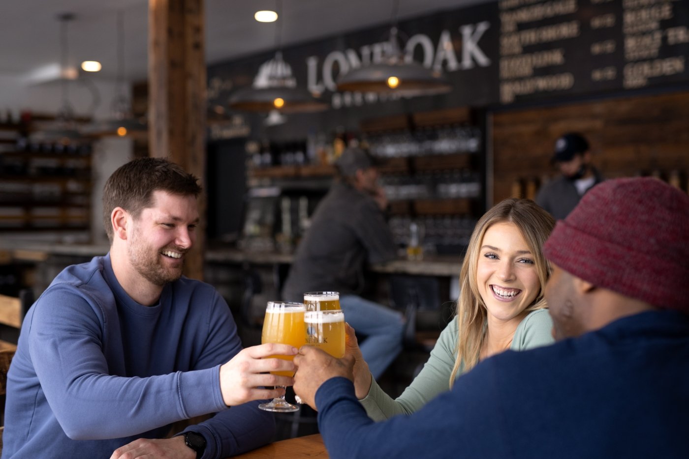 Group of three toast with beers at Lone Oak Brewing CO.