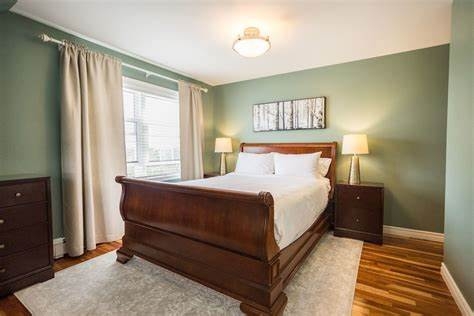 large sleigh bed in a green bedroom at 1 park lane, stratford