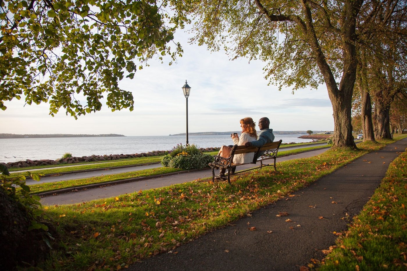 Couple sits on bench in Victoria Park, Charlottetown, PEI