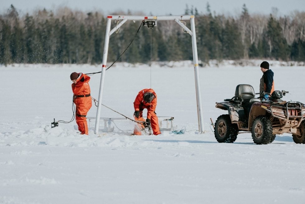 Three fishers on ice for winter mussel harvest