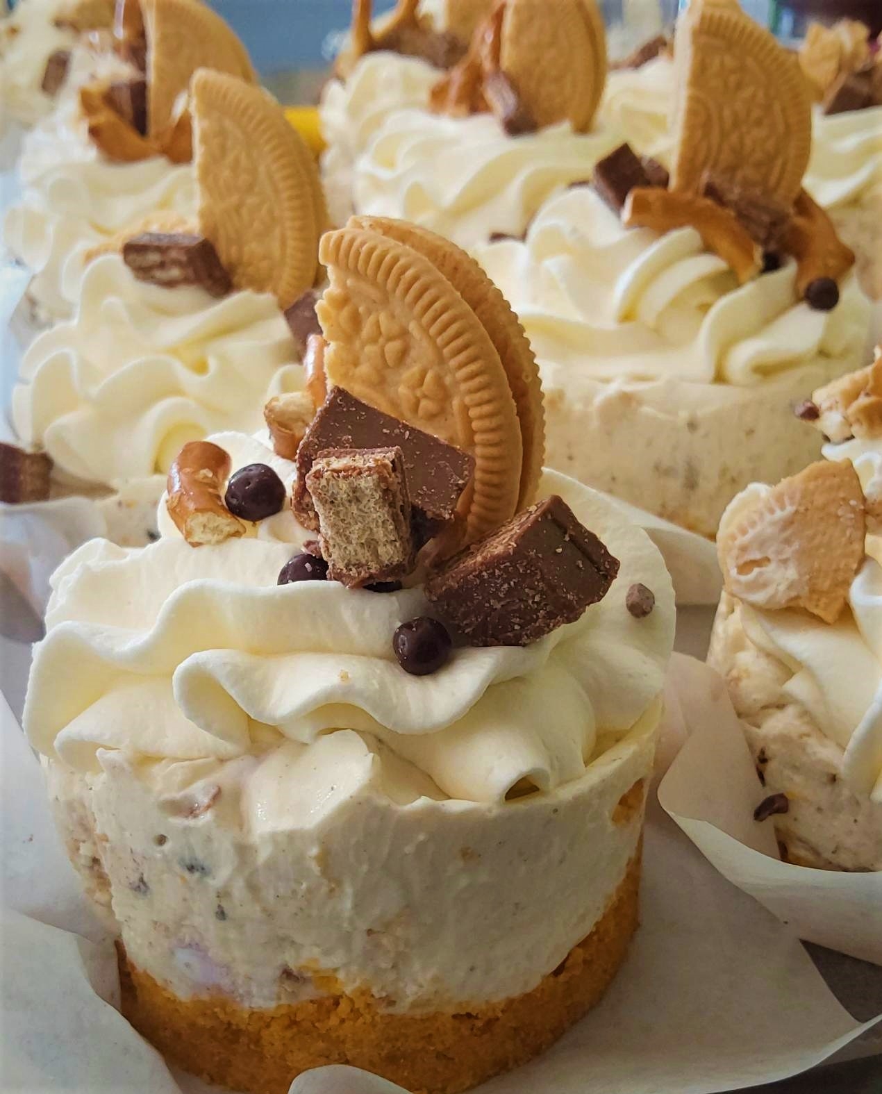 Close-up image of mini cheesecake with candy bar and cookie toppings, Maroon Pig Sweet Shop and Studio