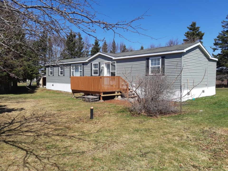 8 Dunes Lane outside photo looking at a grey mini home with small deck on front