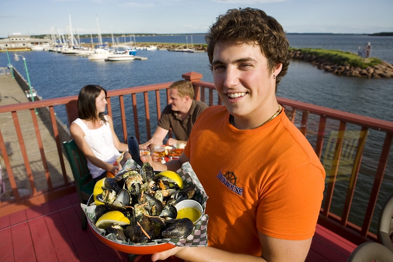 Deckhouse, Summerside, PEI Server holds bowl of steamed PEI mussels
